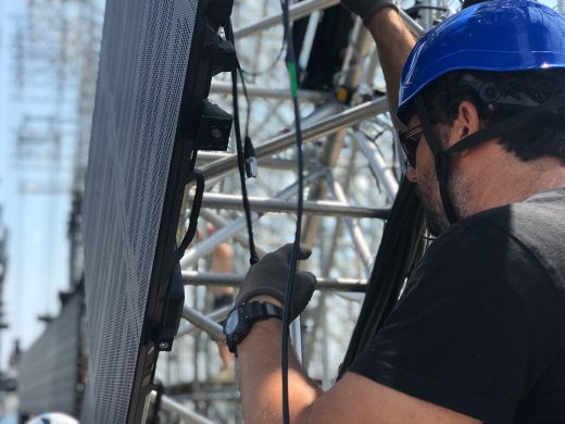 trabajador instala una pantalla led